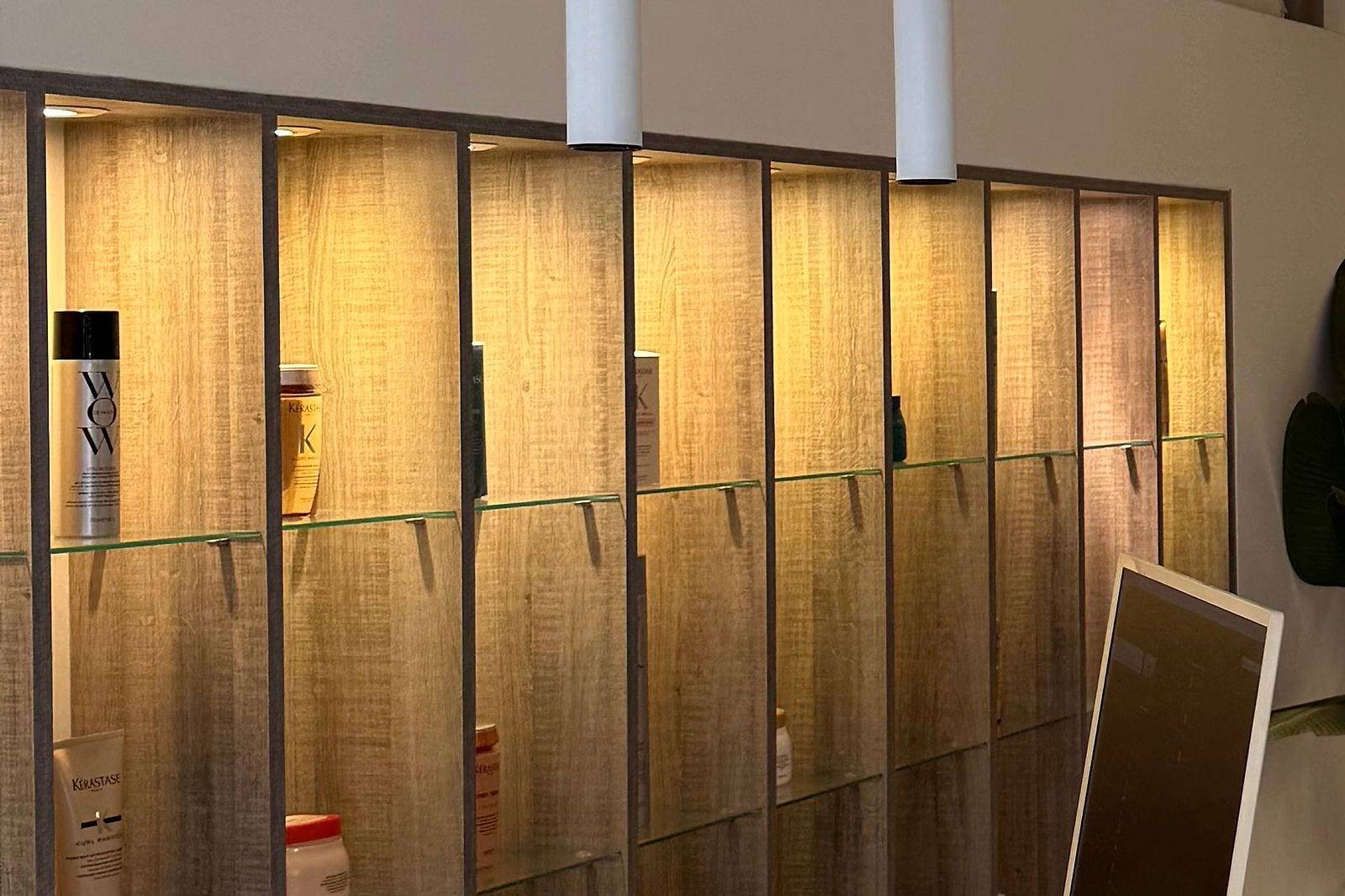 Estanterías iluminadas de madera junto a la recepción